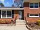 Close-up of the brick house entrance with black shutters and iron handrails at 5108 Melbourne Rd, Raleigh, NC 27606
