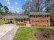 Charming brick home with a well-manicured lawn and inviting carport at 5108 Melbourne Rd, Raleigh, NC 27606