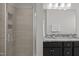 Bathroom featuring a shower, double sinks with granite countertops, and stylish mirrors at 517 Aronia Dr, Hillsborough, NC 27278