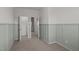 Bedroom with wainscoting, carpet floors, closet, and door leading to other rooms at 517 Aronia Dr, Hillsborough, NC 27278