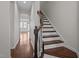 A well-lit entryway with hardwood floors and a staircase featuring wooden banisters and white risers at 517 Aronia Dr, Hillsborough, NC 27278