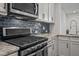 Modern kitchen with stainless steel appliances, granite countertops, dark backsplash and white cabinets at 517 Aronia Dr, Hillsborough, NC 27278