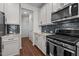 A modern kitchen featuring white cabinets, stainless steel appliances, granite countertops, and hardwood floors at 517 Aronia Dr, Hillsborough, NC 27278