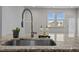 Modern kitchen sink with granite countertops, stainless steel faucet, and natural light from window at 517 Aronia Dr, Hillsborough, NC 27278