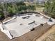 Aerial view of a concrete skate park with various ramps, rails, and a paved walking path at 517 Aronia Dr, Hillsborough, NC 27278