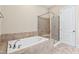 Relaxing bathroom featuring a soaking tub and glass-enclosed shower at 525 Fallon Grove Way, Raleigh, NC 27608