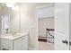 Bright bathroom featuring a vanity with a sink, a mirror, and an open doorway at 525 Fallon Grove Way, Raleigh, NC 27608