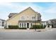 Inviting tan two-story home featuring a well-manicured lawn and a classic black front door at 525 Fallon Grove Way, Raleigh, NC 27608