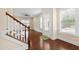 Welcoming foyer with wood floors, staircase, and natural light from large windows at 525 Fallon Grove Way, Raleigh, NC 27608