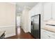 Kitchen with stainless steel refrigerator and white cabinets leading to the laundry room at 525 Fallon Grove Way, Raleigh, NC 27608