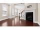 Well-lit living room boasts hardwood floors, fireplace, and large windows at 525 Fallon Grove Way, Raleigh, NC 27608