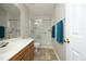 Well-lit bathroom featuring a vanity with sink, a toilet, and a glass-enclosed shower with accessibility bars at 5513 Edgebury Rd, Raleigh, NC 27613