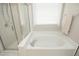 Bathroom with soaking tub, tiled walls, and window at 5513 Edgebury Rd, Raleigh, NC 27613