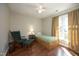 Cozy bedroom featuring a twin bed, rocking chair, and natural light from the window at 5513 Edgebury Rd, Raleigh, NC 27613