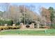 Harrington Grove entrance with brick pillars, stone sign, landscaping, and a prominent American flag at 5513 Edgebury Rd, Raleigh, NC 27613