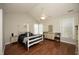 Spacious bedroom featuring hardwood floors, a four-poster bed, and ample natural light at 5513 Edgebury Rd, Raleigh, NC 27613