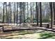 Outdoor playground featuring swings and a slide set in a woodland environment offers a fun recreational space at 5513 Edgebury Rd, Raleigh, NC 27613