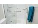 Bright shower features accessibility bars, handheld shower head, seat, and a bright blue towel on a rack nearby at 5513 Edgebury Rd, Raleigh, NC 27613