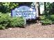 Harrington Grove Swim & Racquet Club sign surrounded by lush greenery and foliage on a bed of pine straw at 5513 Edgebury Rd, Raleigh, NC 27613