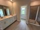 Modern bathroom features a double sink vanity, tiled floor and a view into a shower at 712 Swim Cave Ln, Wendell, NC 27591