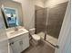 Modern bathroom features a tiled shower, a white vanity, and a view into another room at 712 Swim Cave Ln, Wendell, NC 27591