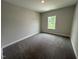 Bedroom with neutral walls, plush gray carpeting, and natural light from a window overlooking a green space at 712 Swim Cave Ln, Wendell, NC 27591