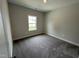 Neutral-toned bedroom featuring plush carpeting, a window providing natural light, and clean, bright white trim at 712 Swim Cave Ln, Wendell, NC 27591