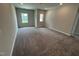 Spacious bonus room features neutral walls, plush gray carpeting, and natural light from two windows at 712 Swim Cave Ln, Wendell, NC 27591