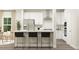Modern kitchen featuring white cabinets, stainless steel appliances, and stylish black bar stools at 712 Swim Cave Ln, Wendell, NC 27591