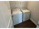 Laundry room featuring a modern washing machine and dryer, with hardwood flooring and a doorway for easy access at 712 Swim Cave Ln, Wendell, NC 27591