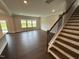 Hardwood floors lead to staircase and living room. Large windows offer ample natural light at 712 Swim Cave Ln, Wendell, NC 27591