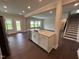 Open-concept living space with dark hardwood floors, leading to a kitchen with island and white cabinets at 712 Swim Cave Ln, Wendell, NC 27591