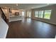 Bright and open living area with hardwood floors, view into kitchen, and glass door to the backyard at 712 Swim Cave Ln, Wendell, NC 27591