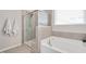 Bathroom featuring a soaking tub and a glass enclosed shower with tile surround at 724 Summer Music Ln, Raleigh, NC 27603