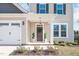 Inviting front porch featuring a decorative wreath on the front door and manicured landscaping at 724 Summer Music Ln, Raleigh, NC 27603