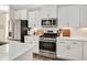 Modern kitchen featuring white cabinets, stainless steel appliances, and a subway tile backsplash at 724 Summer Music Ln, Raleigh, NC 27603