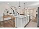 Open kitchen with a large island, modern lighting, and a view into the living room at 724 Summer Music Ln, Raleigh, NC 27603
