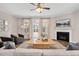 Bright living room featuring a fireplace, ceiling fan, and a glass door for access to the backyard at 724 Summer Music Ln, Raleigh, NC 27603