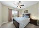 Bedroom with a large window offering scenic views, complemented by a ceiling fan and modern lighting at 73 Vibernum Vw, Four Oaks, NC 27524