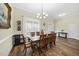 The dining room has wood floors, a dining table with six chairs, and white sheer curtains on the windows at 73 Vibernum Vw, Four Oaks, NC 27524