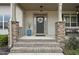 Front porch with stone pillars and a decorative front door at 73 Vibernum Vw, Four Oaks, NC 27524