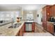 View of the kitchen with stainless steel dishwasher and granite countertops open to the living room and dining area at 73 Vibernum Vw, Four Oaks, NC 27524