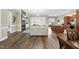 Open-concept living room with wood floors, stone fireplace, adjacent to dining and kitchen at 73 Vibernum Vw, Four Oaks, NC 27524