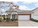 Charming townhome featuring a two-car garage, brick accents, and a well-manicured front yard at 734 Hornchurch Loop, Cary, NC 27519