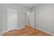 Hallway featuring hardwood floors and white doors offers seamless transition between living spaces at 734 Hornchurch Loop, Cary, NC 27519