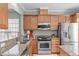 Spacious kitchen with granite counters, stainless appliances, and wooden cabinets at 734 Hornchurch Loop, Cary, NC 27519