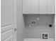 Functional laundry room area with white cabinets, washer and dryer hookups for convenience at 734 Hornchurch Loop, Cary, NC 27519