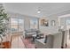 Bright living room with hardwood floors, a gray sofa, and ample natural light at 734 Hornchurch Loop, Cary, NC 27519