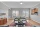 Well-lit living room with hardwood floors, neutral furniture, and a view to the kitchen at 734 Hornchurch Loop, Cary, NC 27519
