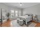 Bright main bedroom with hardwood floors, large windows, and sitting area at 734 Hornchurch Loop, Cary, NC 27519